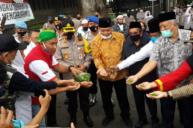 Sejumlah peserta aksi dan pejabat yang hadir saat memakam makaroni dalam Aksi Damai Bela Kanjeng Nabi di depan Gedung DPRD Kota Malang, Senin (2/11/2020).