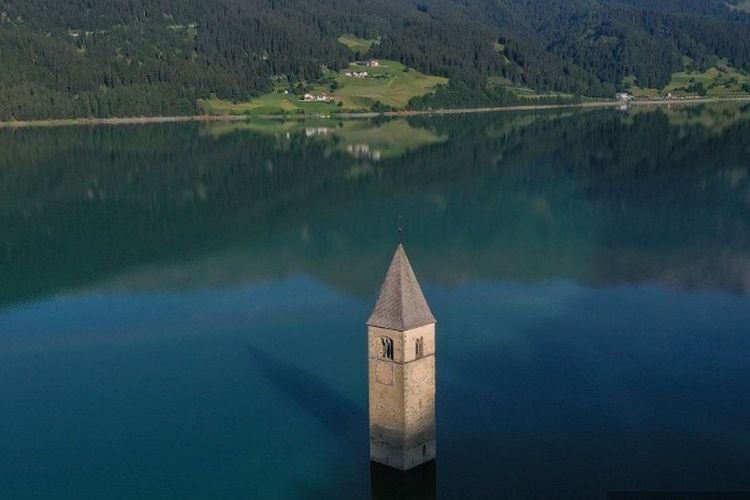 Foto udara yang diambil pada 10 Juli 2020 di kota baru Curon Venosta (Graun im Vinschgau), sekitar 100 km barat laut dari Bolzano, Italia Utara, menunjukkan menara lonceng gereja kota tua Curon yang tenggelam di danau Resia.