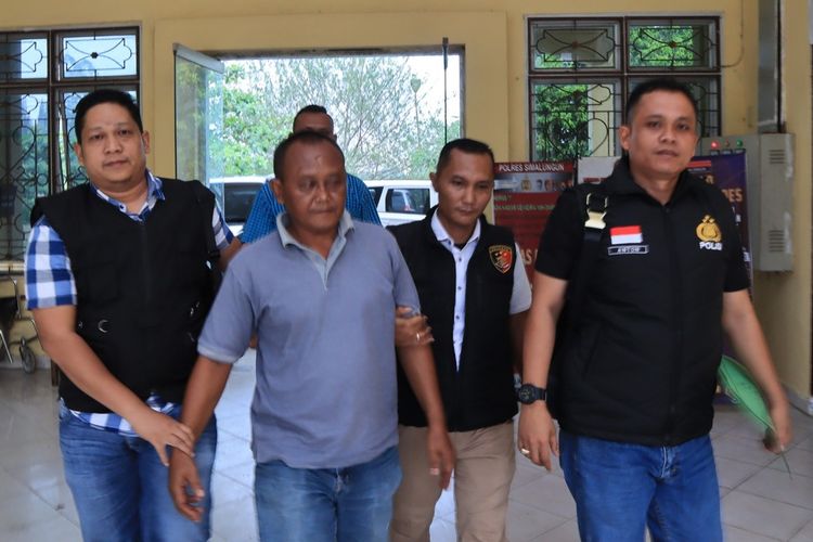Mantan Pangulu Nagori Purwodadi, Kabupaten Simalungun Haryo Guntoro (ke dua dari kiri) digiring polisi ke Mako Polres Simalungun, Selasa (23/4/2024).