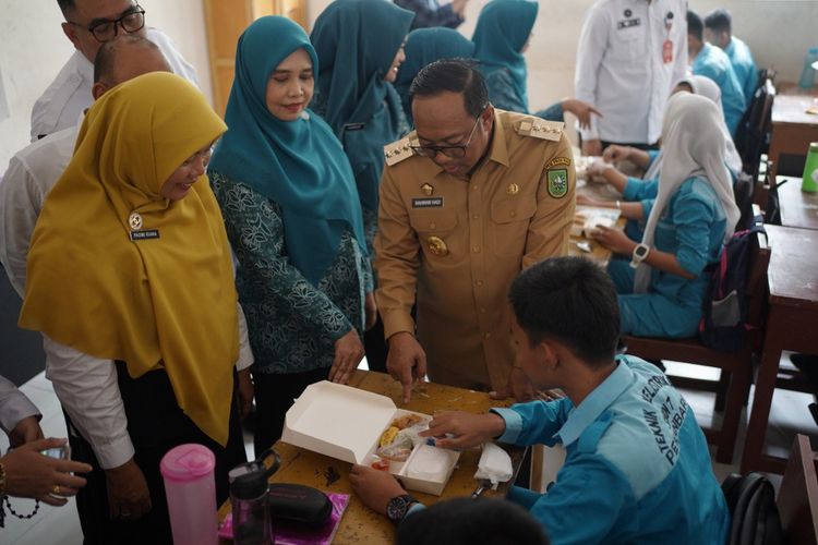 Penjabat (Pj) Gubernur Riau (Gubri) Rahman Hadi saat meninjau pelaksanaan simulasi atau uji coba program Makan Siang Bergizi Gratis di Provinsi Riau, pada Rabu, (6/11/2024). 
