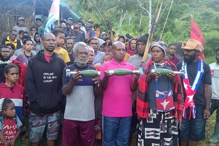 Warga Papua memegang mortir yang tidak meledak setelah serangan udara Oktober oleh pasukan Indonesia di Kiwirok, Kabupaten Pegunungan Bintang, Papua, Indonesia, 1 November 2021.