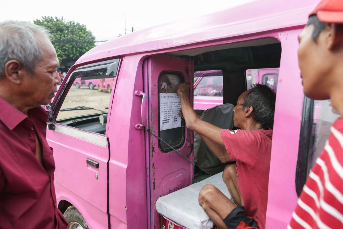 Sopir angkutan kota D09 menempelkan kenaikan tarif sementara pasca kenaikan bahan bakar minyak subsidi Pertalite dan Solar di Terminal Bayangan Kampung Sawah di Depok, Senin (5/9/2022). Paguyuban sopir angkutan kota D09 dan D10 di Depok melakukan penyesuaian kenaikan tarif sementara sebesar Rp 1000 imbas kenaikan BBM subsidi jenis Pertalite dan Solar.