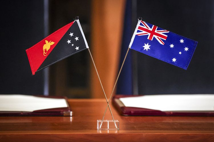 Bendera Papua Nugini dan Australia terpasang di meja saat Perdana Menteri Australia Anthony Albanese dan Perdana Menteri Papua Nugini James Marape menandatangani Perjanjian Pukpuk di Istana Parlemen, Canberra, 6 Oktober 2025.