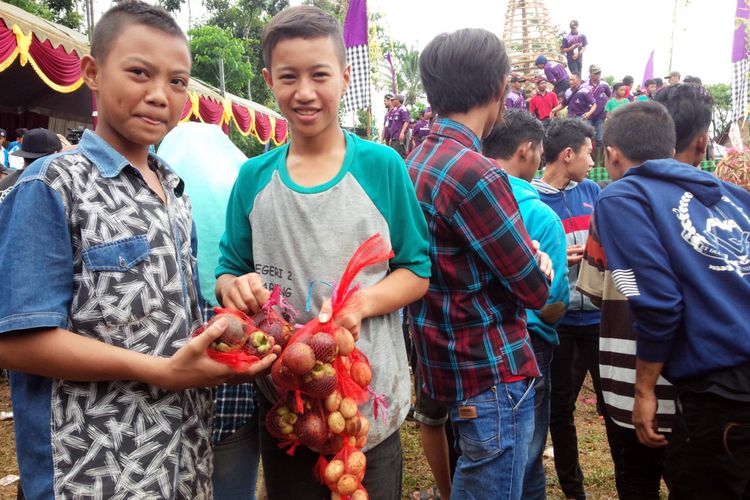 Nur Ali Ridlo (dua dari kiri), salah satu pengunjung asal Desa Karangan Kecamatan Bareng Jombang, pada acara tumpengan manggis di lapangan Desa Jarak Kecamatan Wonosalam Kabupaten Jombang Jawa Timur, Minggu (24/3/2019). Dia berhasil mendapatkan beberapa butir buah manggis yang dibagikan secara gratis. 