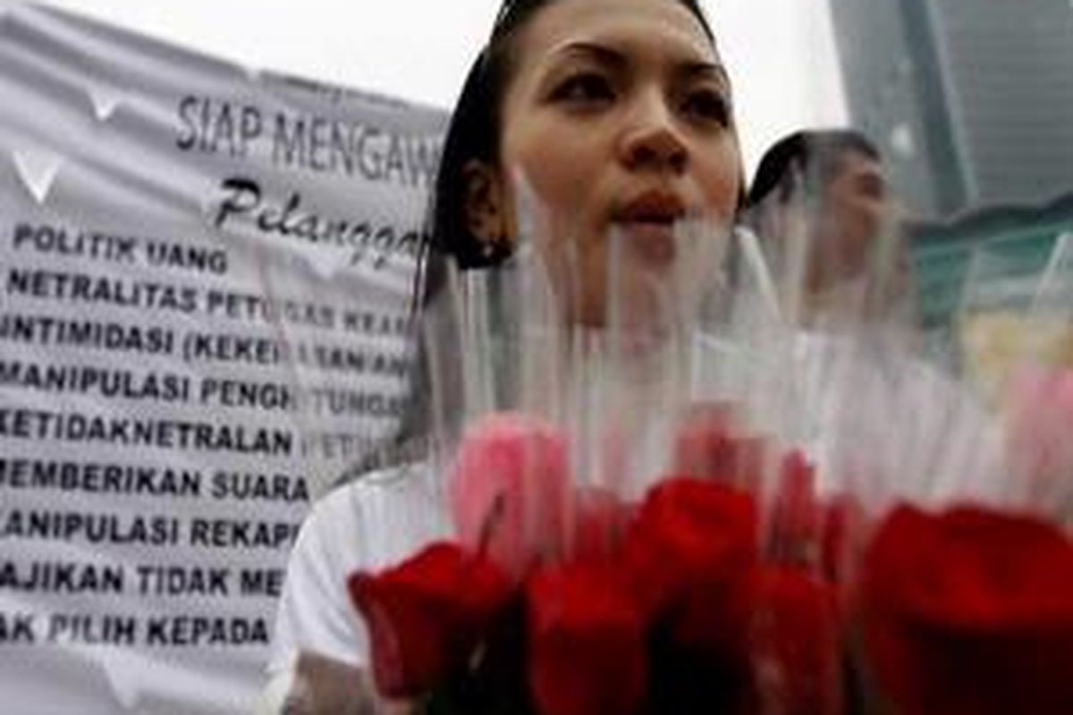 Bawaslu membagikan bunga dan selebaran seruan di Bundaran Hotel Indonesia, Rabu (8/4).