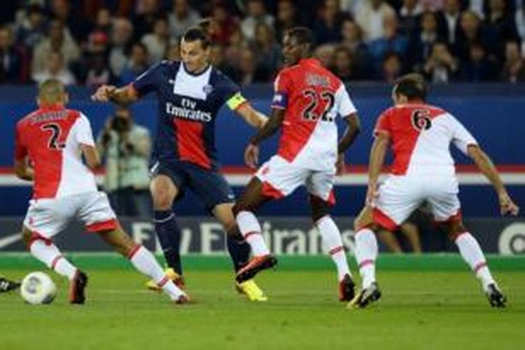 Striker Paris Saint-Germain, Zlatan Ibrahimovic (biru), mendapat pengawalan ketat dari para pemain AS Monaco dalam lanjutan Ligue 1 di Stadion Parc des Princes, Paris, Minggu atau Senin (23/9/2013) dini hari WIB.