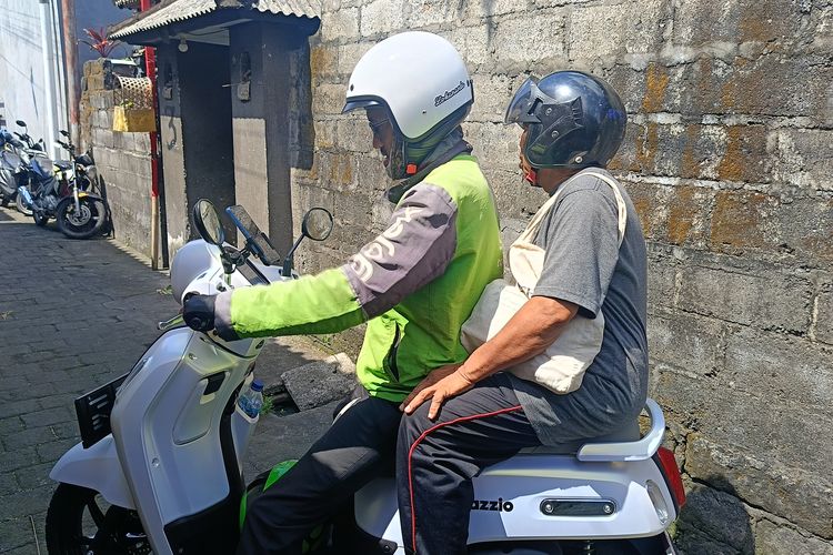 Pengemudi ojek online saat mengantar penumpang di Denpasar, Selasa (20/5/2025).