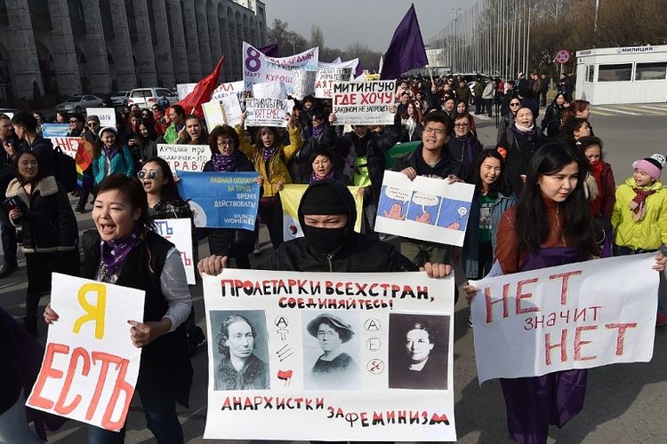 Seorang pengunjuk rasa membawa poster bertuliskan, Kaum proletar di seluruh dunia bersatu anarkis untuk feminisme. Pengunjuk rasa ini melakukan Long March dengan tajuk Hari Perempuan Internasional di Bishkek, 8 Maret 2020. 