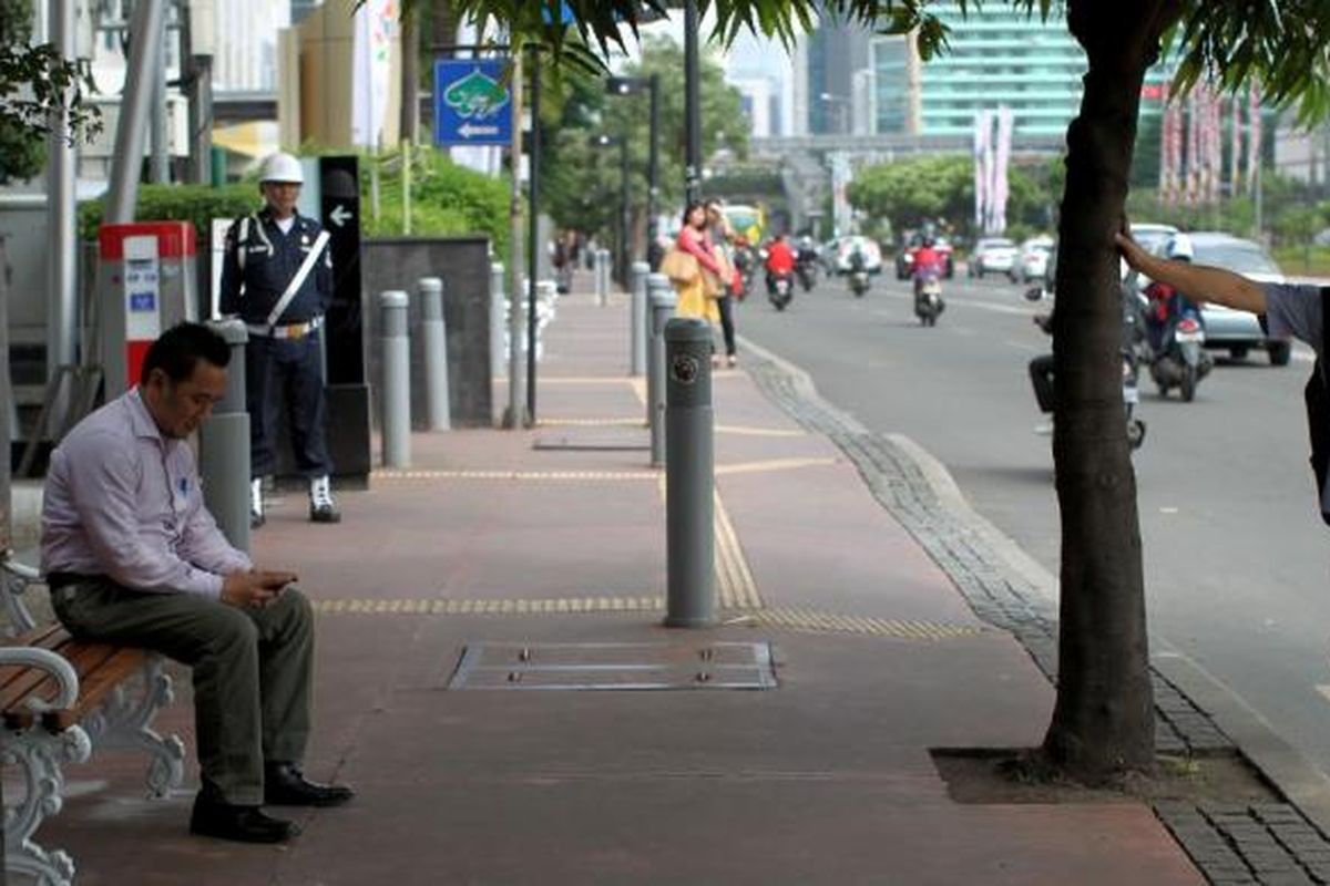 Warga duduk di bangku taman yang terpasang sejak semalam di kawasan Jalan MH Thamrin, Jakarta, Rabu (19/6/2013). Sebanyak 340 unit bangku taman dipasang di Jalan Sudirman, Jalan MH Thamrin hingga kawasan Medan Merdeka untuk memberikan kenyamanan kepada pengguna trotoar di Jakarta.