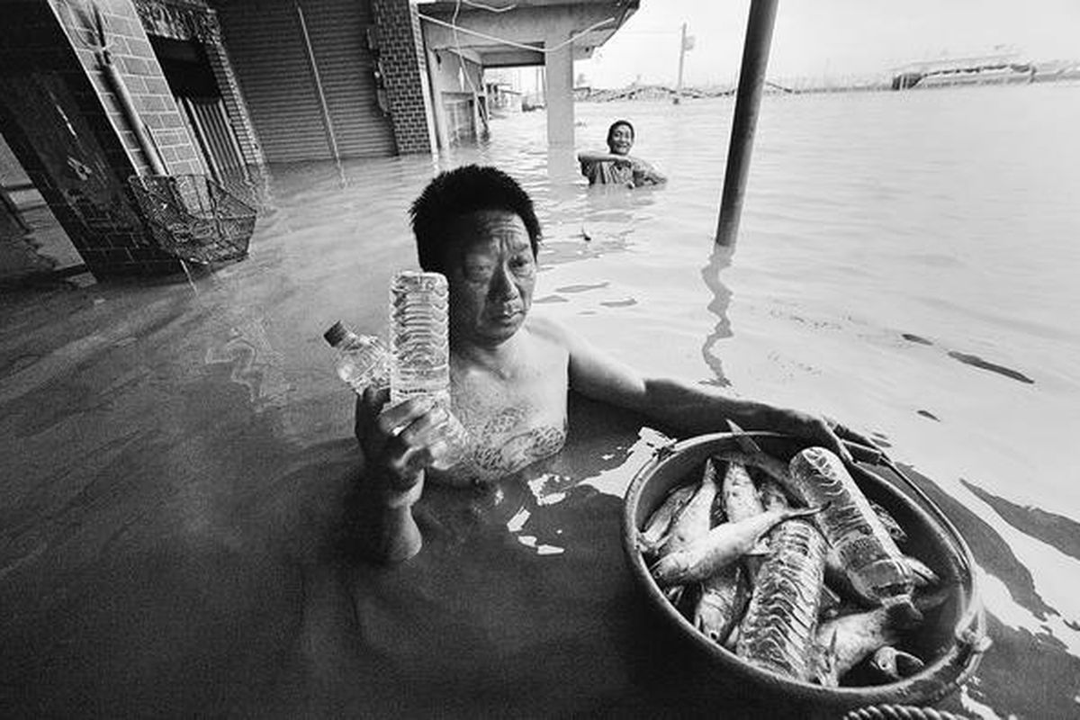 Penduduk lokal di Chiatung, Distrik Pingtung, Taiwan Selatan, yang menjadi korban banjir lantaran topan Morakot, menerima bantuan air minum dalam botol ketika ia tengah menangkap ikan di tengah banjir. Setidaknya seorang tewas dan delapan lainnya hilang setelah topan Morakot melanda Taiwan pada Sabtu (8/8). 