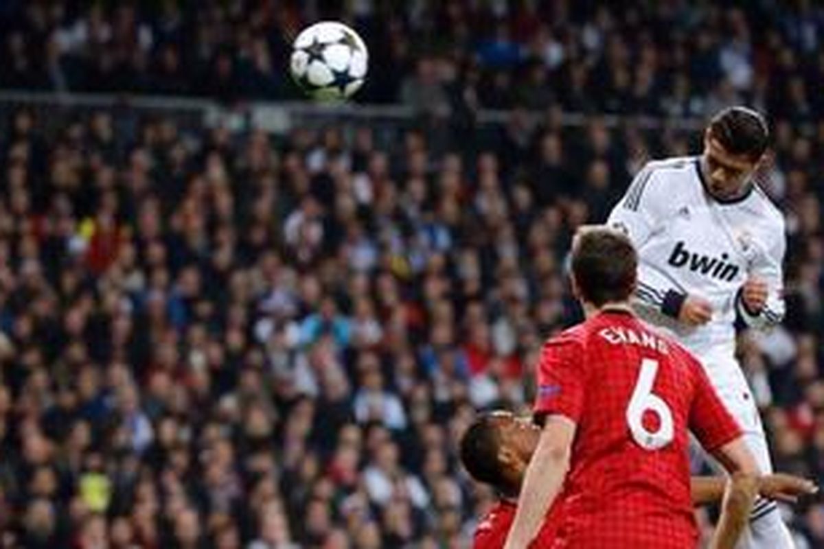 Gelandang Real Madrid, Cristiano Ronaldo, menyundul bola yang berujung gol ke gawang mantan klubnya, Manchester United, pada leg pertama 16 besar Liga Champions, di Santiago Bernabeu, Rabu (13/2/2013).