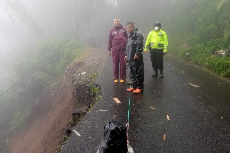 Petugas BPBD Bandung Barat meninjau jalan yang tergerus longsor di Kecamatan Cisarua, Senin (27/2/2023).