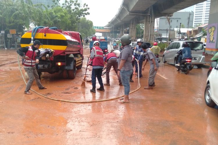 anggota PPSU kelurahan Semanggi dan pihak pengerjaan proyek bersihkan sisa lumpur akibat banjir di Jalan Dr Satrio, Kuningan, Jakarta Selatan, Selasa (17/12/2019)