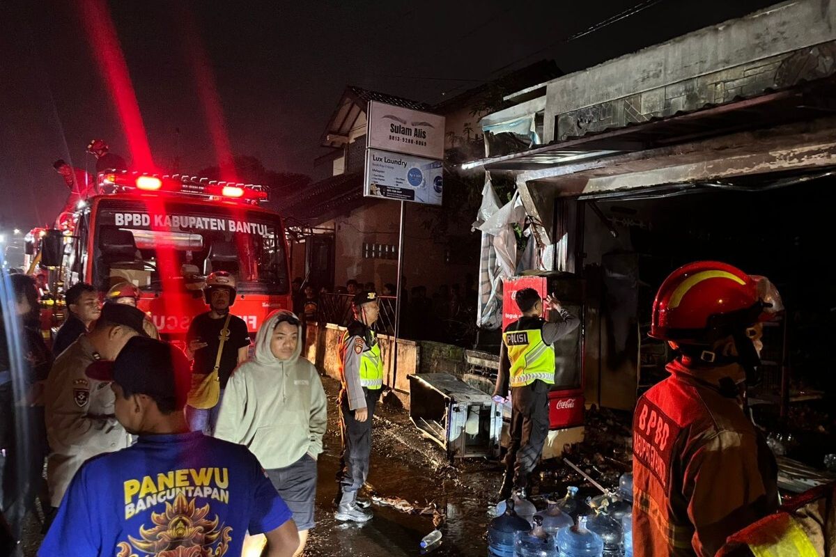 Petugas kepolisian dan pemadam kebakaran di lokasi toko kelontong terbakar di Wonocatur Rt 09, Kaluraha Banguntapan, Kapanewon Banguntapan, Bantul, Daerah Istimewa Yogyakarta, Kamis (4/12/2025) malam.