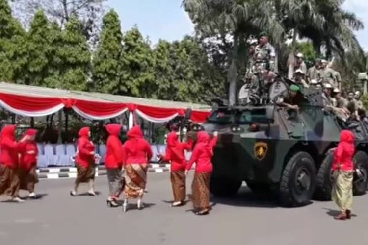 Panser Anoa yang tengah beraksi sambil melaju pelan dicegat sekelompok ibu berkebaya merah dalam peringatan HUT ke-72 TNI di Lapangan Rampal Kota Malang, Kamis (5/10/2017).