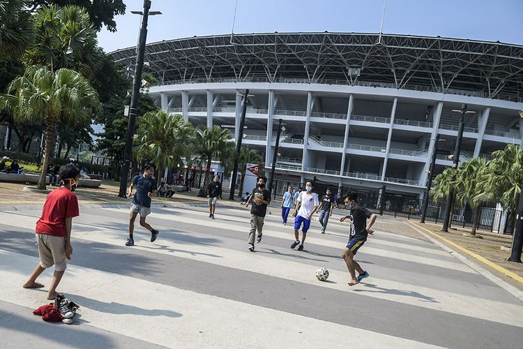Warga bermain sepak bola di kawasan Stadion Utama Gelora Bung Karno (SUGBK) di Senayan, Jakarta, Minggu (13/9/2020). Jelang penerapan Pembatasan Sosial Berskala Besar (PSBB) total yang rencananya dilaksanakan pada Senin (14/9/2020) masih banyak masyarakat yang melakukan olahraga dan beraktivitas di luar rumah.