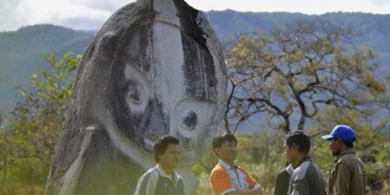 Lelaki suku Lore subetnis To Bada berbincang di depan arca menhir Palindo di Lembah Bada, tepatnya di Padang Sepe, Desa Bewa, Kecamatan Lore Selatan, Kabupaten Poso, Sulawesi Tengah, Jumat (30/8/2013), dalam kegiatan Ekspedisi Budaya Lembah Bada. Palindo adalah arca megalitik terbesar yang ada di Lembah Bada. 