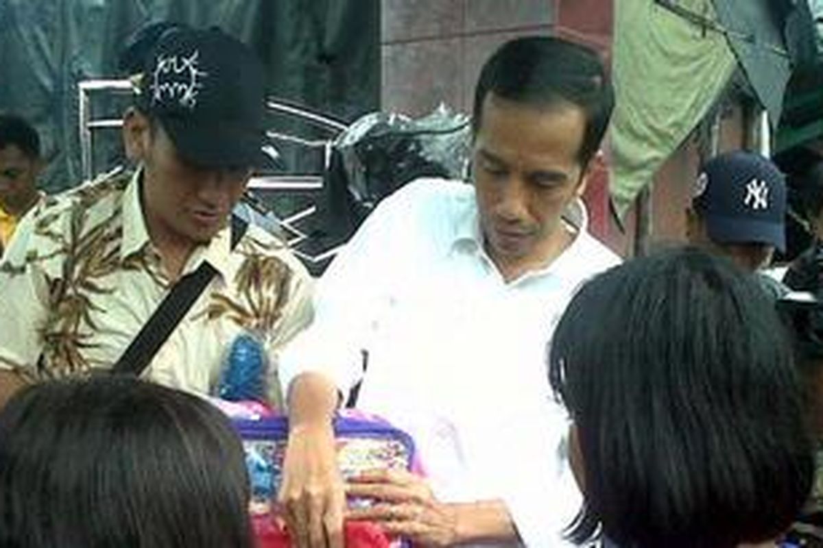 Gubernur DKI Jakarta Joko Widodo saat membagikan tas sekolah untuk anak-anak di kampung nelayan, Kelurahan Cilincing, Kecamatan Cilincing, Jakarta Utara, Sabtu (2/2/2013).