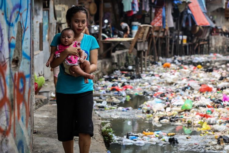 Warga berjalan di dekat kali yang dipenuhi sampah di Jln. Jati Bunder, Kel. Kebon Melati, Kec. Tanah Abang, Jakarta Pusat , Selasa (5/9/2017). Pemprov DKI Jakarta bersama dengan PemerintaPemprov DKI Jakarta bersama dengan Pemerintah Pusat akan menata kawasan kumuh melalui pencanangan program 100-0-100 yang dicanangkan Kementerian Pekerjaan umum dan Perumahan Rakyat dengan target Jakarta bebas dari kawasan kumuh pada tahun 2019. 