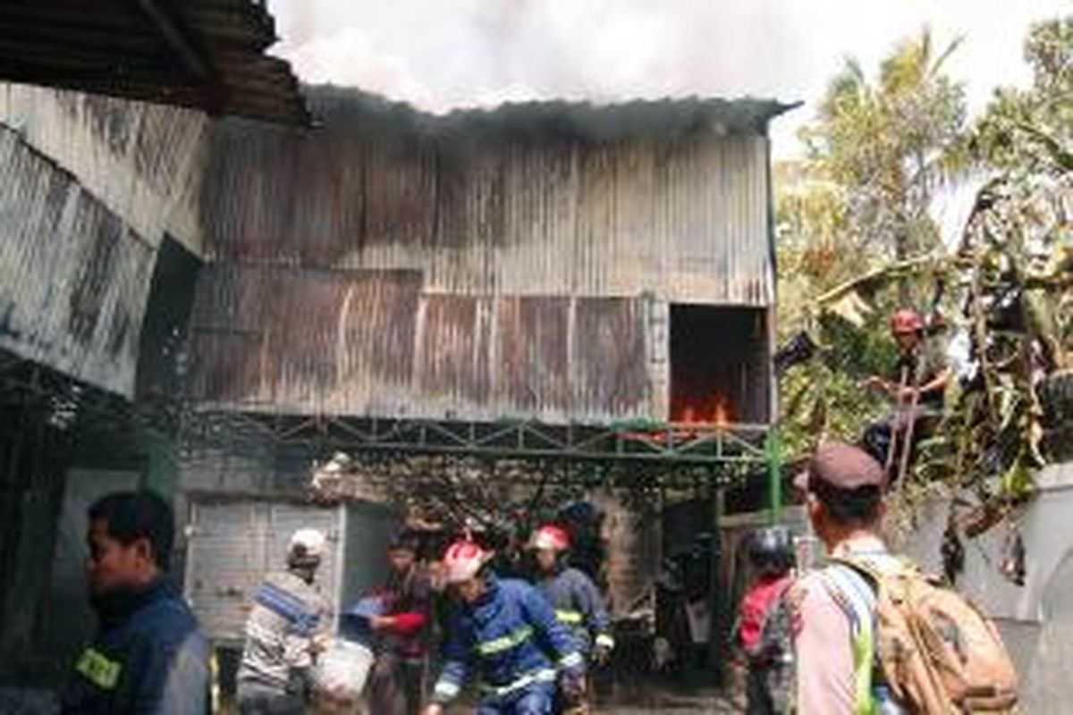 Petugas pemadam kebakaran dibantu warga sekitar memadamkan api yang menghanguskan sebuah gudang penyimpanan sterofoam dan plastik di Jalan Raya Jakarta-Bogor,  Kelurahan Pabuaran, Cibinong, Kabupaten Bogor, Kamis (26/11/2015) 