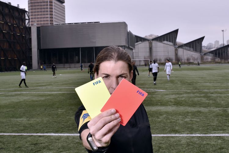 Wasit sepak bola asal Perancis, Stephanie Frappart, memegang kartu merah dan kuning pada 24 Februari 2016 di Paris.