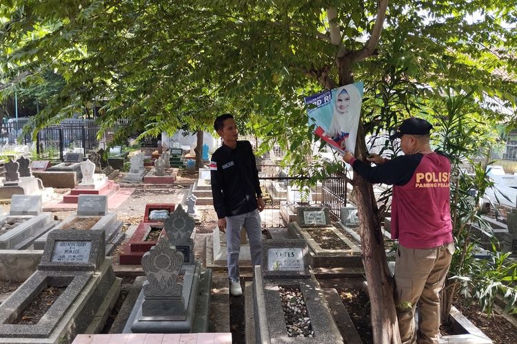 Komisioner Bawaslu Kota Cirebon Nurul Fajri bersama Satpol PP menertibkan APK yang dipasang di area kuburan atau TPU Kemlaten Kecamatan Harjamukti Kota Cirebon, Rabu (24/1/2024)