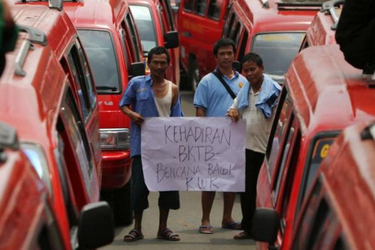 Para sopir angkutan kota Koperasi Wahana Kalpika (KWK) jurusan Grogol - Muara Karang berunjuk rasa di depan Balaikota DKI Jakarta, Selasa (11/2/2014). Mereka menolak beroperasinya bus kota terintegrasi busway (BKTB) karena dianggap menurunkan pendapatan mereka.