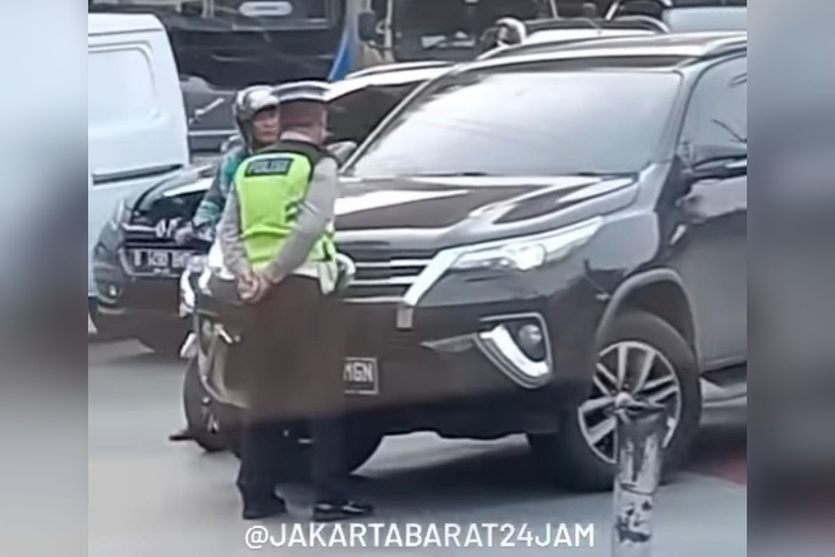 Polisi lalu lintas mencoba untuk menghalangi sopir Fortuner yang langgar rambu lalu lintas di kawasan Rawa Buaya, Jakarta Barat, Senin (20/3/2023). 