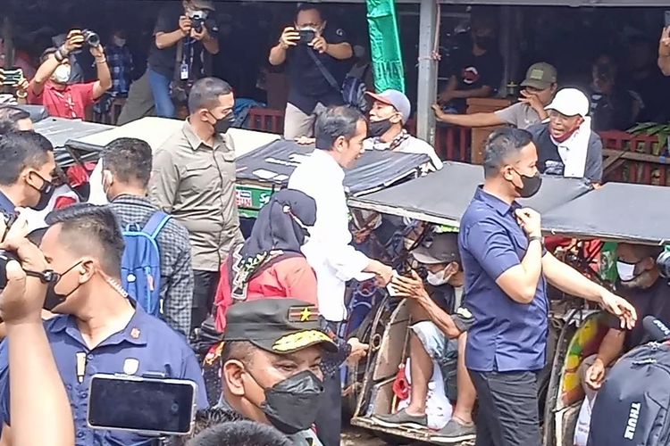 Presiden Joko Widodo (Jokowi) memberikan give away kepada tukang becak saat berkunjung ke Lampung, Sabtu (3/9/2022).