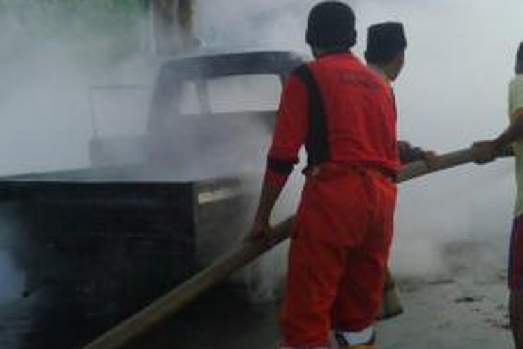 Pasukan pemadam kebakaran mematikan api yang membakar mobil pengangkut BBM, Sabtu (7/12/2013).