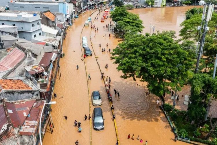 Foto udara sejumlah mobil melintasi banjir akibat luapan air Sungai Ciliwung di Jatinegara, Jakarta, Selasa (04/03).