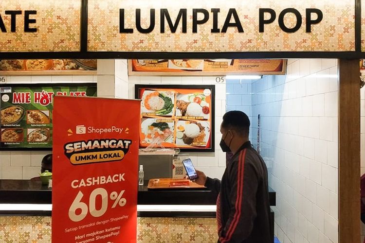 Seorang Pengunjung Sedang Melakukan Transaksi di Sentra Kuliner Simpang Lima Semarang.