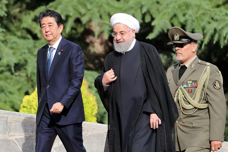 Presiden Iran Hassan Rouhani (tengah) menyambut Perdana Menteri Jepang Shinzo Abe (kiri) yang datang berkunjung ke Teheran, Rabu (12/6/2019).