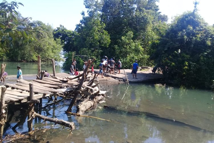 Warga Desa Lidi pikul motor pakai kayu di Kali Pinarangkat, Kecamatan Rana Mese, Kabupaten Manggarai Timur, Flores, NTT, Jumat (21/6/2019). 