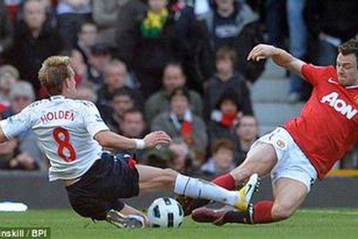 Gelandang Bolton Wanderers, Stuart Holden (kiri) berebut bola dengan bek Manchester United, Jonny Evans, pada pertandingan Premier League, Sabtu (19/3/2011). Perebutan ini berujung cederanya lutut Holden.