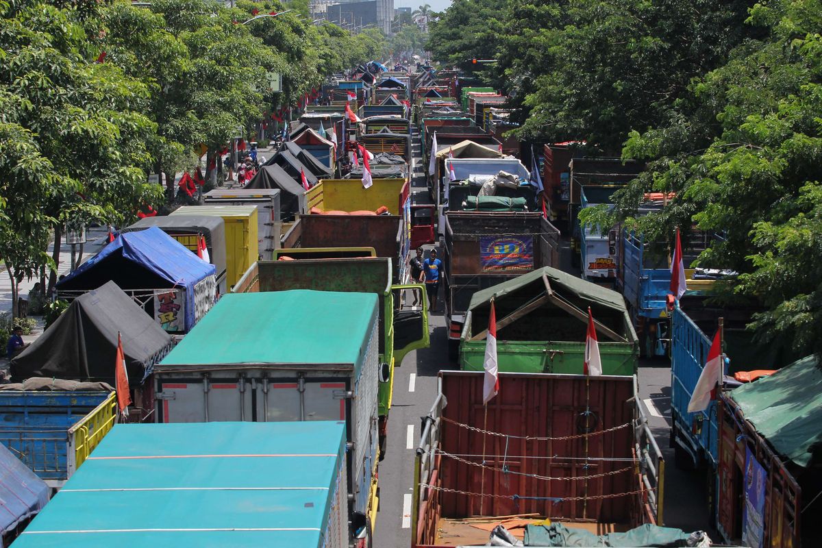 Sejumlah truk berbagai jenis terparkir saat pengemudinya berunjuk rasa di frontage Jalan A Yani, Surabaya, Jawa Timur, Selasa (22/2/2022). Para pengemudi truk itu memprotes aturan terkait over dimension and over loading (ODOL).