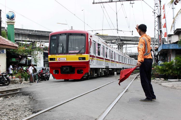 Penjaga Jalan Lintasan (PJL) Asep mengamankan perlintasan dari pengguna jalan yang hendak melintas di Stasiun Ancol, Jakarta Utara, Sabtu (7/12/2019). Petugas PJL harus ekstra hati-hati karena dalam menjaga perlintasan kereta karena di lakukan secara manual tanpa palang otomatis.