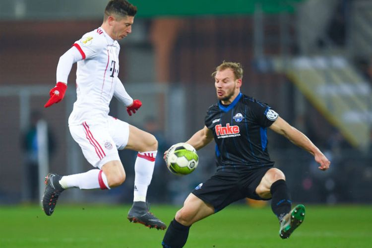 Penyerang FC Bayern Muenchen, Robert Lewandowski (baju putih), berebut bola dengan pemain SC Paderborn, Christian Strohdiek pada pertandingan perempat final di Stadion Benteler-Arena, Paderborn, Jerman, Rabu (7/2/2018) dini hari WIB.