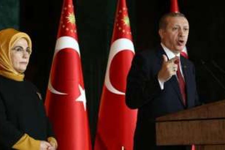 Presiden Turki Recep Tayyip Erdogan sedang memberikan pidato didampingi istrinya, Emine.