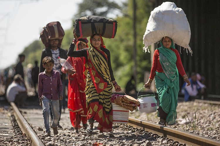 Buruh migran berjalan menuju desa mereka selama karantina wilayah (lockdown) di New Delhi, India, Minggu (29/3/2020). Pemerintah India pada 24 Maret lalu mulai memberlakukan lockdown selama 21 hari di seluruh wilayah negara itu dalam upaya mengendalikan penyebaran COVID-19.