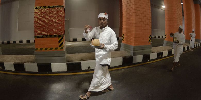 Pemuka agama Hindu memercikkan air suci saat Upacara Melaspas atau penyucian Underpass Simpang Tugu Ngurah Rai, Badung, Bali, Rabu (12/9/2018). Upacara Melaspas dilakukan sebelum Underpass yang dibangun untuk mengurangi kemacetan di kawasan Bandara Internasional I Gusti Ngurah Rai itu diresmikan dan dioperasionalkan untuk mendukung pelaksanaan pertemuan IMF dan Bank Dunia pada bulan Oktober 2018