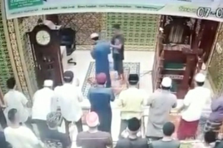 Tangkapan layar rekaman CCTV detik-detik imam masjid ditampar seorang pria berbaju kaos hitam di Masjid Baitul Arsy di Jalan Srikandi, Kelurahan Delima, Kecamatan Bina Widya, Kota Pekanbaru, Riau, Jumat (7/5/2021).