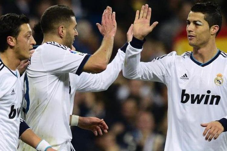 Penyerang Real Madrid dari Perancis, Karim Benzema (tengah), merayakan golnya dengan rekan-rekan seklubnya, gelandang Jerman Mesut Ozil (kiri), dan bomber dari Portugal Cristiano Ronaldo (kanan) saat berlaga melawan Athletic Bilbao dalam laga pekan ke-12 Liga BBVA di Stadion Santiago Bernabeu, Sabtu (17/11/2012). Madrid akhirnya menang 5-1. 