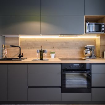Ilustrasi lemari dapur atau kitchen set warna abu-abu di dapur modern.