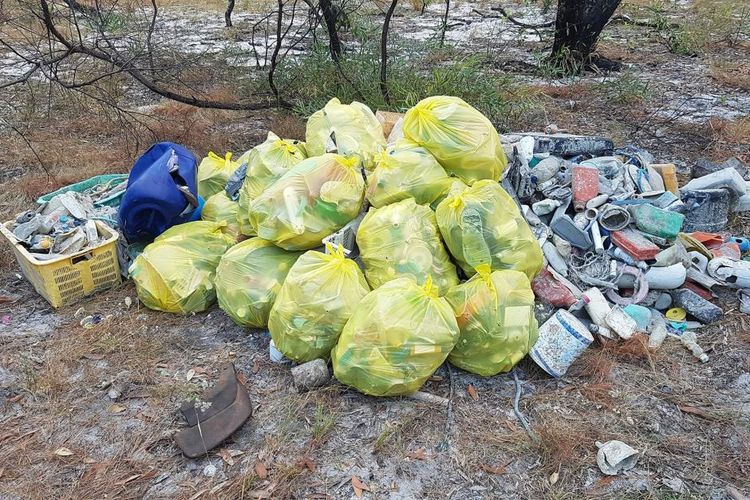 Tumpukan kantong sampah yang dipenuhi limbah domestik seperti sikat gigi, gantungan baju dan plastik keras. 