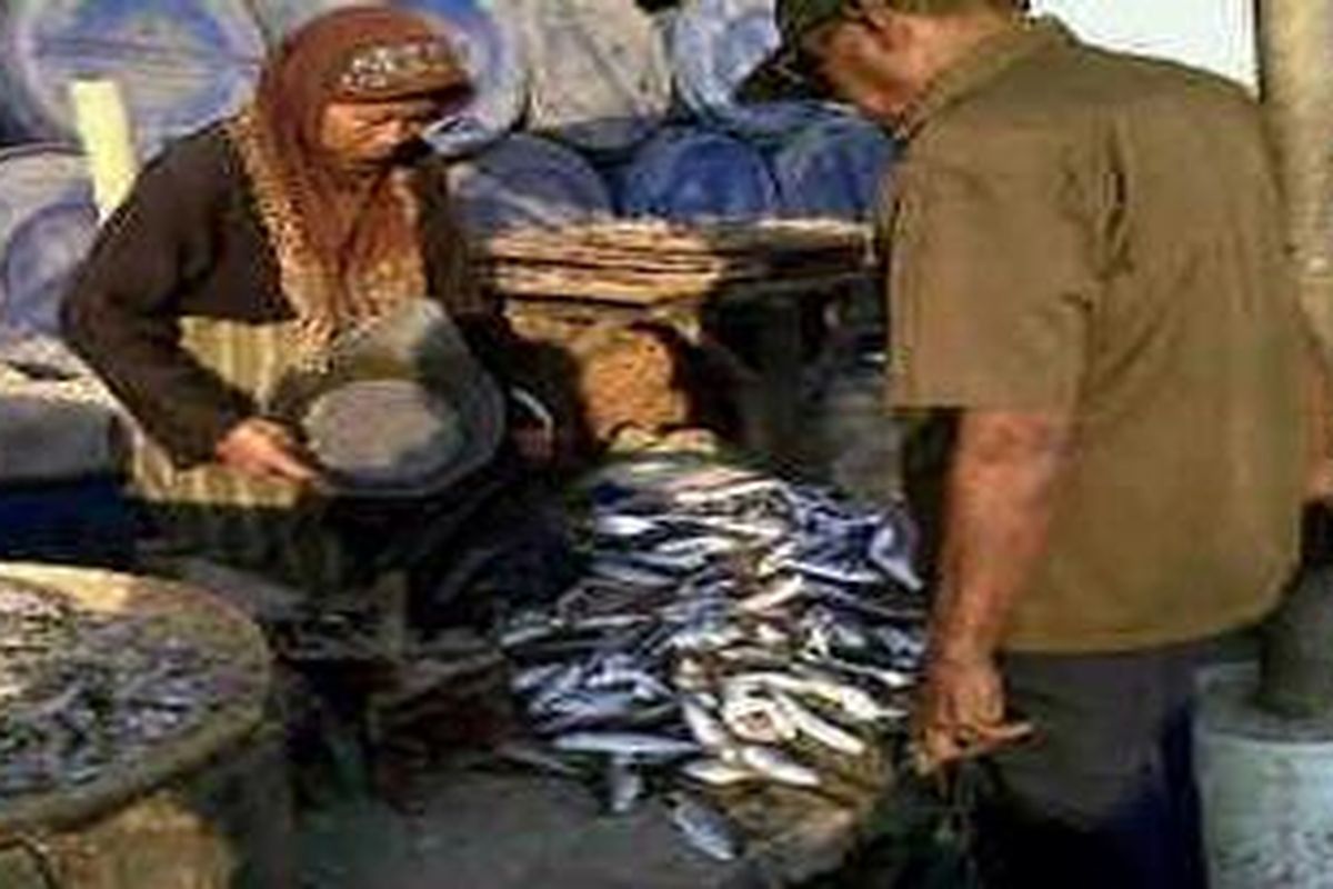 Dua orang nelayan sedang bertransaksi hasil tangkapan mereka di Pasar Tambaklorok, Semarang, Jawa Tengah, Jumat (22/7/2011)