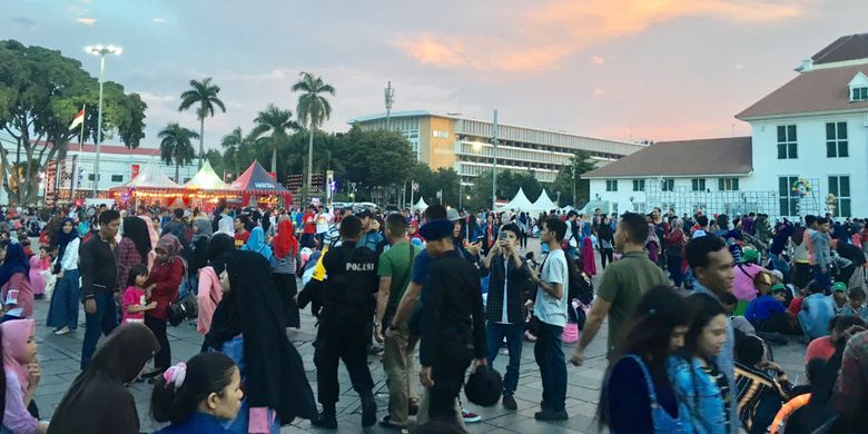 Wisata Kota Tua dipadati pengunjung, tepatnya duduk lesehan di pelataran Museum Fatahillah saat malam tahun baru 2018, Jakarta, Minggu (31/12/2017).