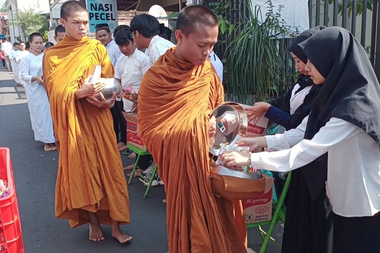 Para biksu menerima sedekah dari para warga dalam kegiatan tradisi Pindapata jelang Hari Raya Waisak di Dusun Ngandat, Desa Mojorejo, Kota Batu, Jawa Timur pada Kamis (1/6/2023).