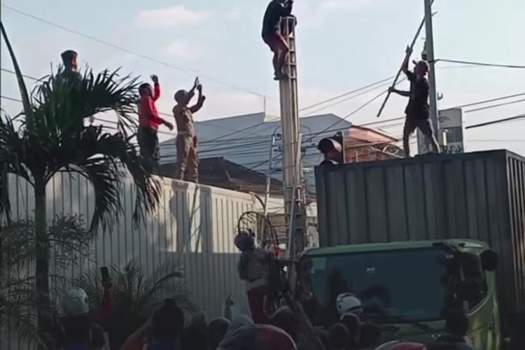 Foto: Seorang pria depresi naik ke tiang penerangan jalan umum (PJU) sambil berteriak histeris pada Minggu (20/7/2025). 