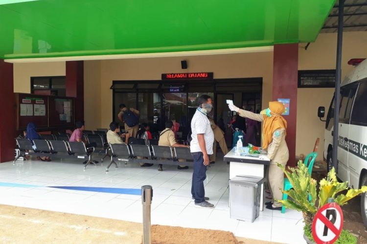 Petugas medis memeriksa suhu badan seluruh pengunjung di Puskesmas Kejobong, Purbalingga, Jawa Tengah, Senin (23/3/2020).